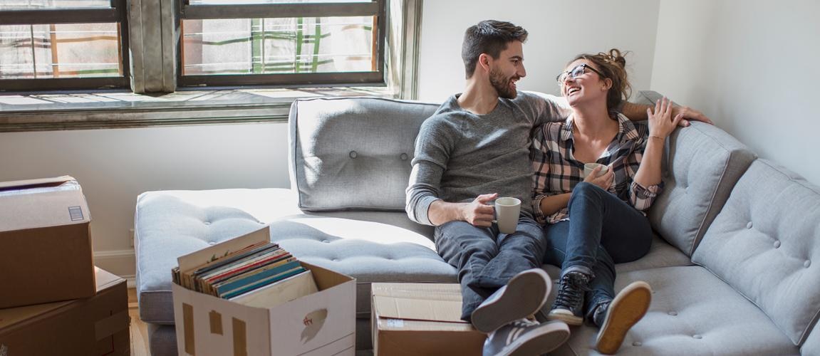 couple sitting on couch in new apartment